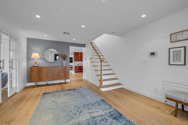 entrance foyer with stairs, wood finished floors, visible vents, and recessed lighting