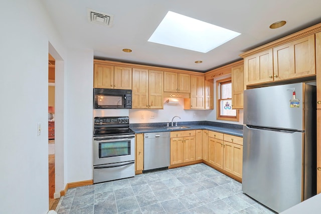 44 Karen Joy Dr, Middletown, NY 10940 - kitchen featuring appliances with stainless steel finishes, light brown cabinets, a skylight, dark countertops, and a sink