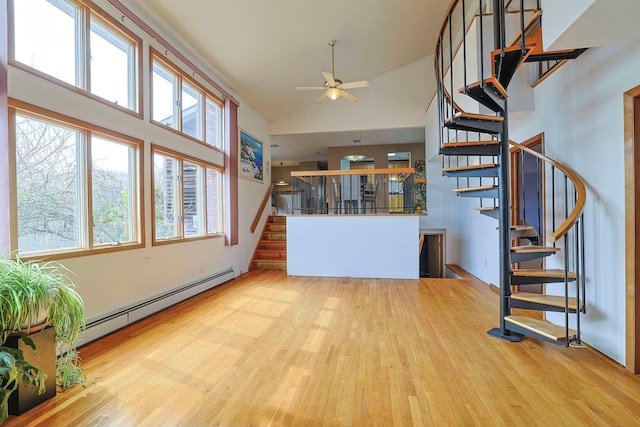 44 Karen Joy Dr, Middletown, NY 10940 - unfurnished living room with a baseboard heating unit, stairs, wood finished floors, ceiling fan, and high vaulted ceiling