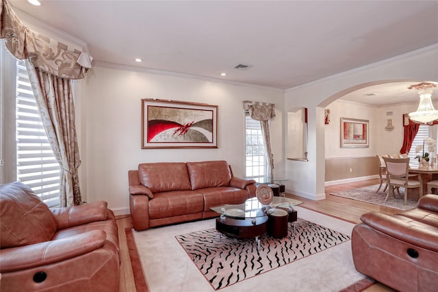 living room with recessed lighting, arched walkways, wood finished floors, and ornamental molding