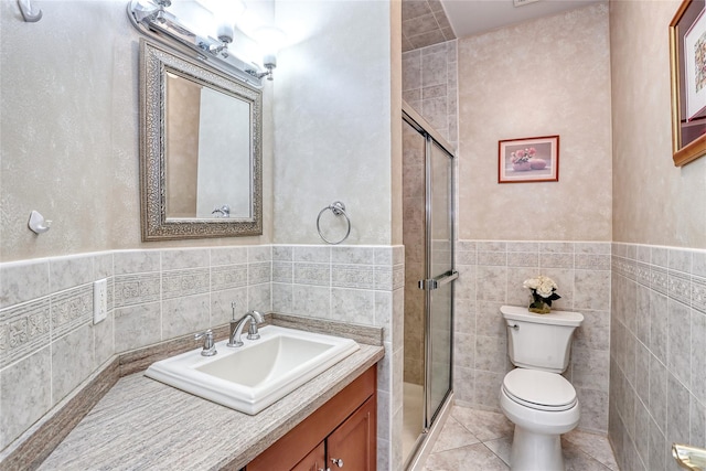 full bath with tile walls, toilet, a shower stall, vanity, and tile patterned flooring