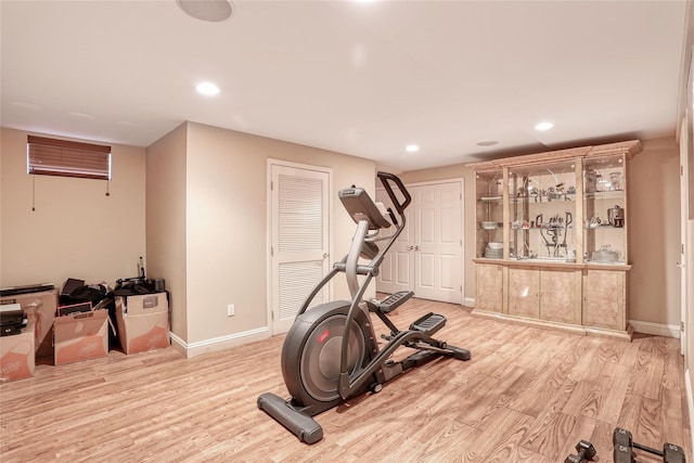 exercise area featuring baseboards, wood finished floors, and recessed lighting