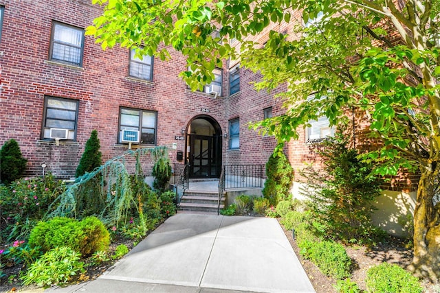 property entrance with a patio area and brick siding