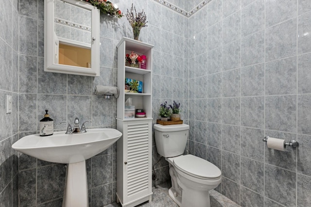 bathroom with tile walls and toilet