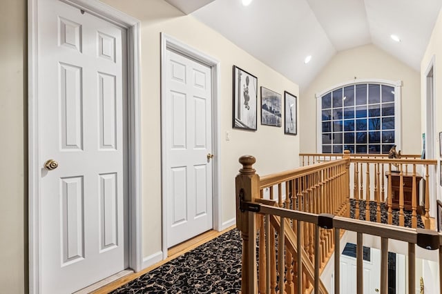 hallway with recessed lighting, light wood-style floors, lofted ceiling, and an upstairs landing