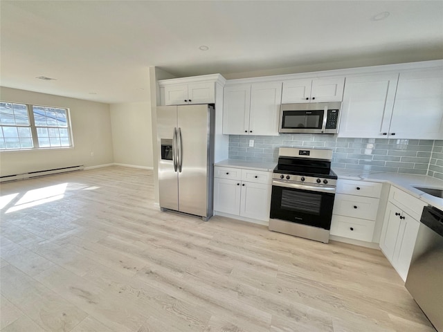 kitchen with a baseboard heating unit, light countertops, appliances with stainless steel finishes, and white cabinets