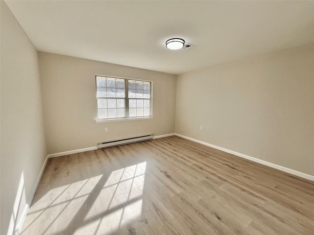 unfurnished room featuring a baseboard radiator, light wood-style flooring, and baseboards