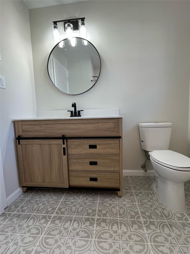 half bath with tile patterned flooring, toilet, vanity, and baseboards