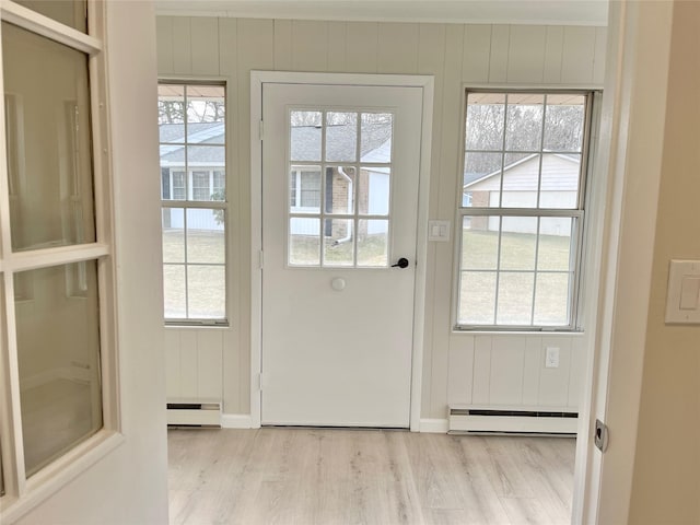 entryway featuring a baseboard heating unit, light wood-type flooring, and a healthy amount of sunlight