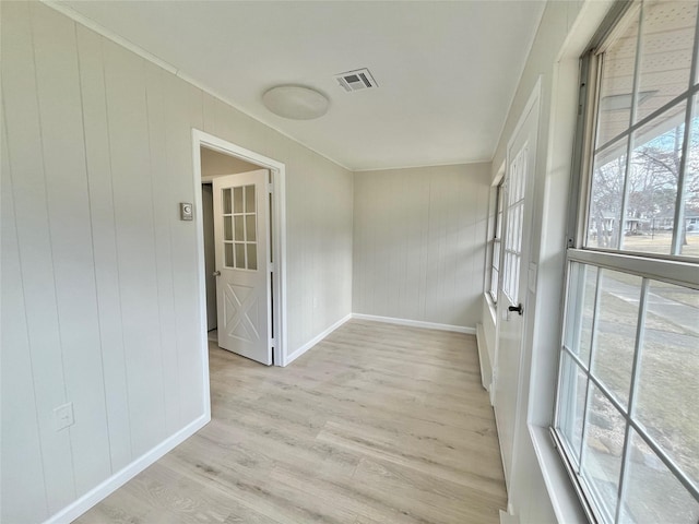 unfurnished room with baseboards, visible vents, and light wood-style floors