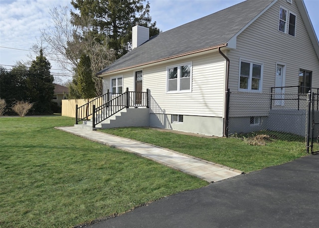 view of front of house featuring a chimney, a front yard, and fence