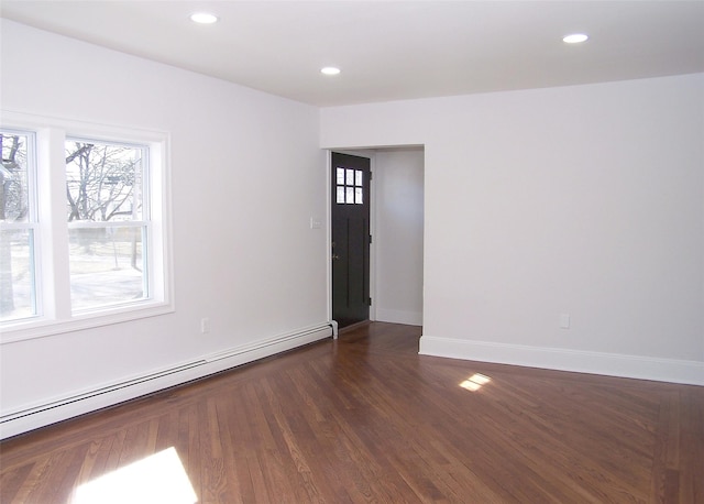 unfurnished room featuring a baseboard heating unit, dark wood-style flooring, baseboards, and recessed lighting