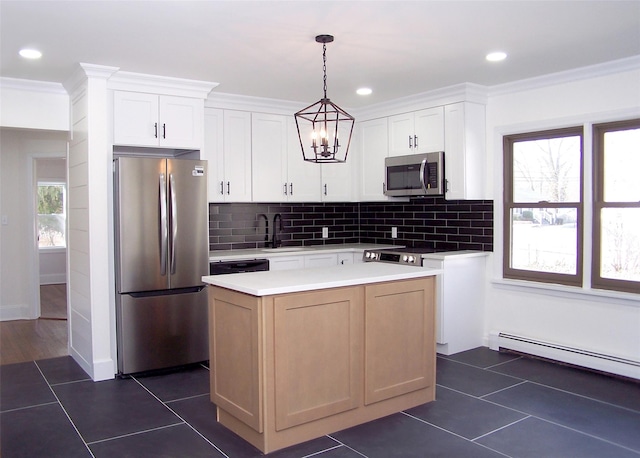 kitchen featuring white cabinetry, light countertops, appliances with stainless steel finishes, a center island, and pendant lighting