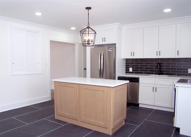 kitchen featuring appliances with stainless steel finishes, a center island, white cabinetry, pendant lighting, and a sink