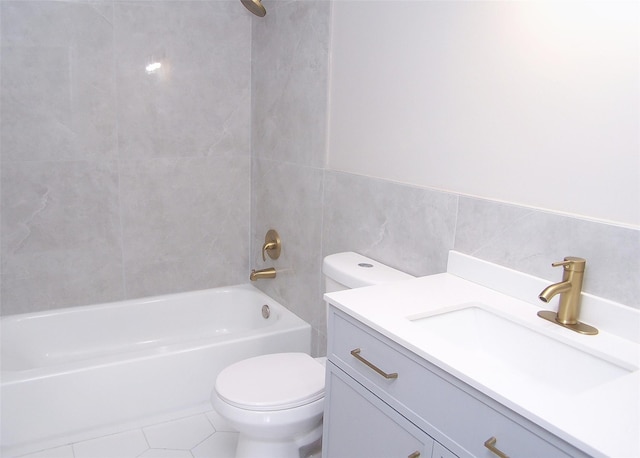 bathroom featuring toilet, shower / tub combination, tile patterned floors, vanity, and tile walls