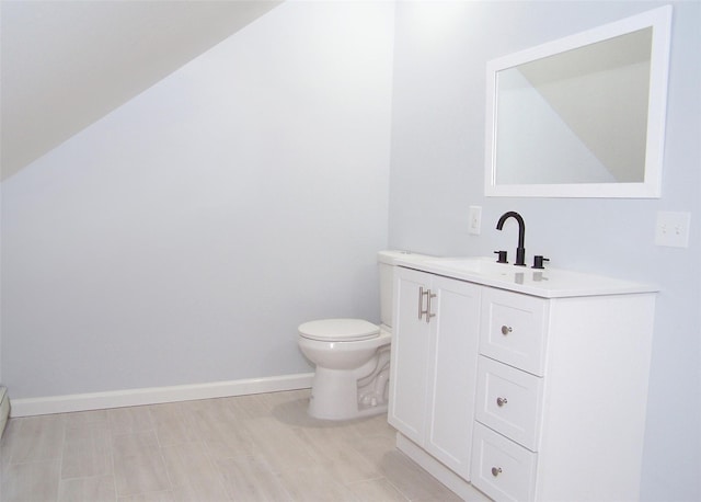 bathroom with toilet, baseboards, and vanity