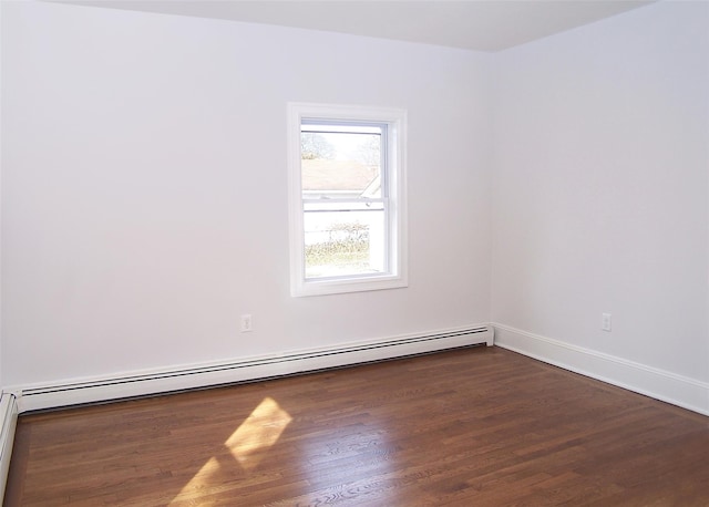 empty room with dark wood-style floors, baseboards, and baseboard heating