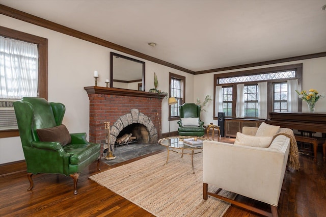 living area featuring dark wood-style floors, a fireplace, baseboards, and crown molding