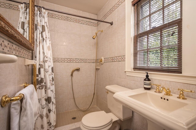 bathroom featuring a sink, a shower stall, and toilet