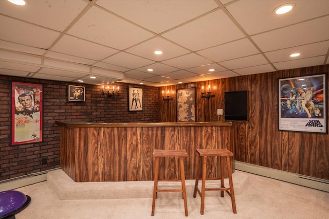 bar featuring a baseboard heating unit, light carpet, wooden walls, and a dry bar