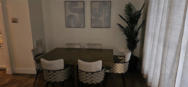 dining space featuring dark wood-style flooring, visible vents, and baseboards