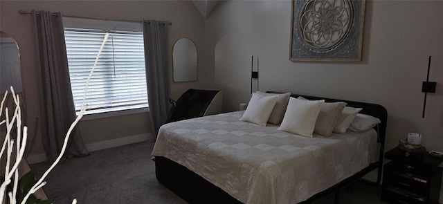 bedroom featuring arched walkways, dark carpet, and baseboards