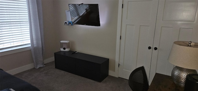 bedroom with baseboards and dark carpet