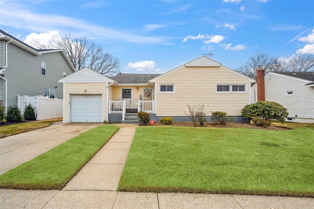 view of front of home with a garage, a front yard, concrete driveway, and fence