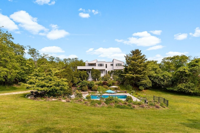 view of yard featuring a balcony and an outdoor pool