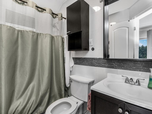 bathroom featuring toilet, backsplash, curtained shower, vanity, and tile walls