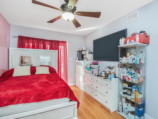 bedroom with ceiling fan, light wood finished floors, and visible vents