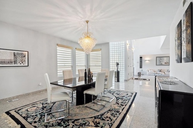 dining area featuring granite finish floor, visible vents, and a chandelier