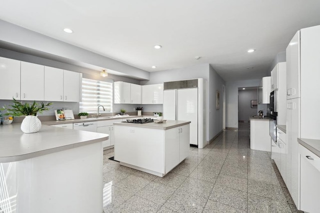 kitchen with recessed lighting, white cabinets, light countertops, and a kitchen island