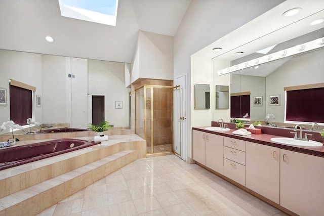 bathroom with a garden tub, a skylight, a sink, and a shower stall