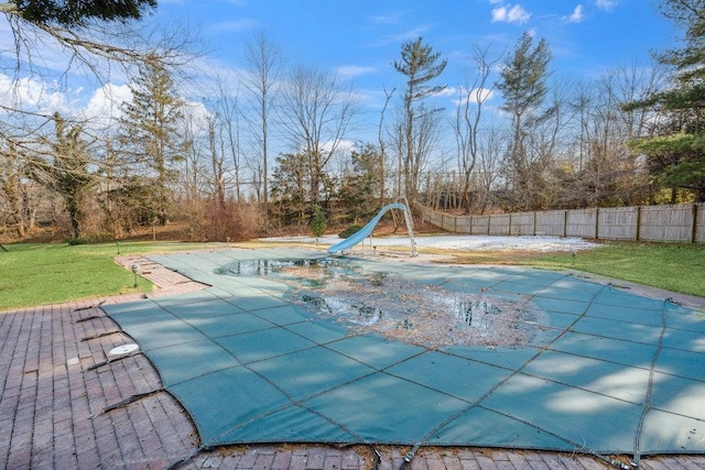 view of pool with a fenced in pool, a yard, a patio, fence, and a water slide