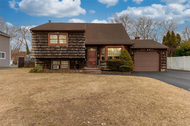 view of front of property featuring a garage, driveway, and fence