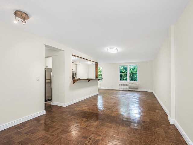 unfurnished living room with radiator and baseboards