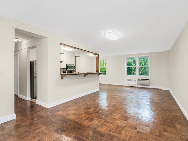 unfurnished living room featuring radiator heating unit and baseboards