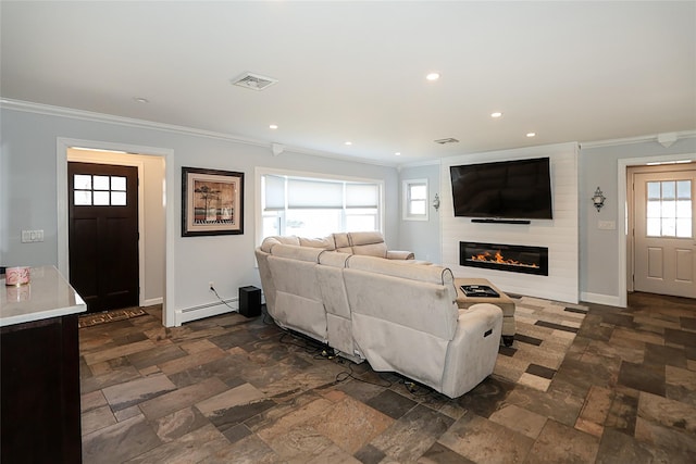 living room featuring visible vents, baseboard heating, ornamental molding, a large fireplace, and baseboards