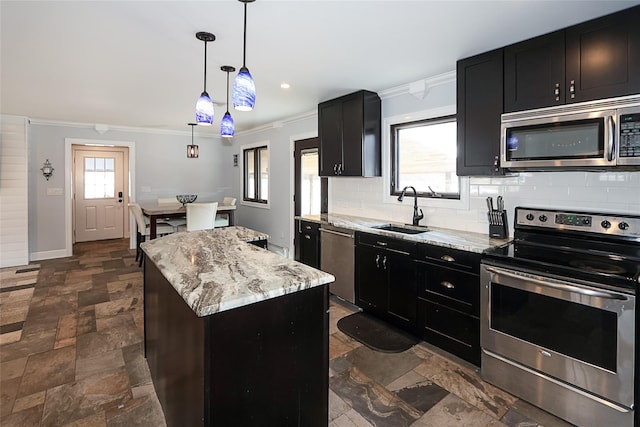 kitchen featuring stone tile floors, appliances with stainless steel finishes, a center island, pendant lighting, and a sink