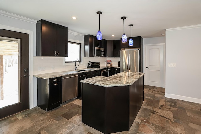 kitchen featuring stone finish floor, appliances with stainless steel finishes, a center island, pendant lighting, and a sink