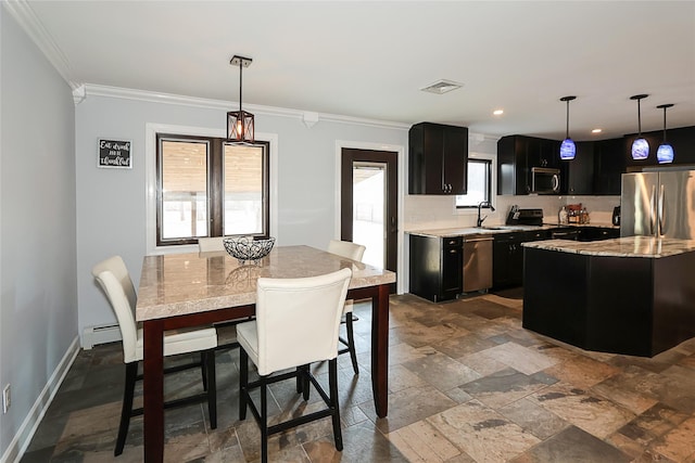 kitchen featuring a center island, decorative light fixtures, baseboard heating, appliances with stainless steel finishes, and a sink