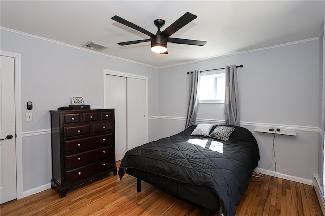 bedroom featuring light wood-style flooring, visible vents, and ornamental molding