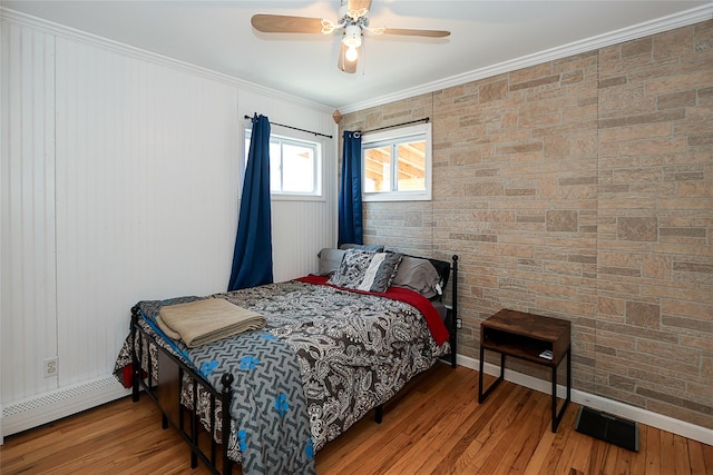 bedroom featuring visible vents, a baseboard radiator, ceiling fan, ornamental molding, and wood finished floors