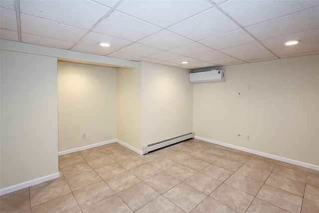 finished basement with a baseboard radiator, a paneled ceiling, recessed lighting, baseboards, and a wall mounted AC