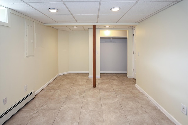 finished basement featuring light tile patterned floors, a drop ceiling, recessed lighting, baseboards, and baseboard heating