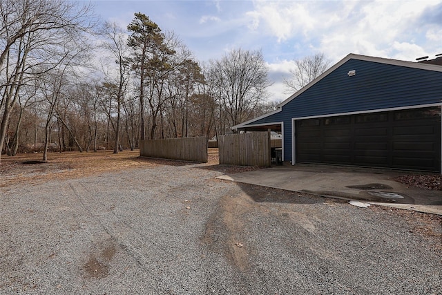 garage with driveway and fence