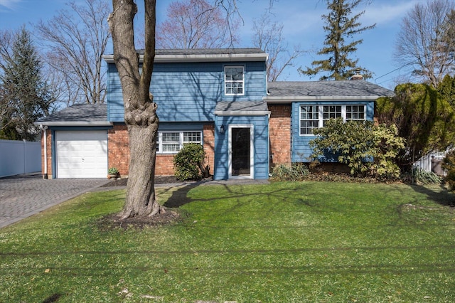 view of front of house featuring a front lawn, decorative driveway, fence, a garage, and brick siding