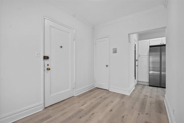 foyer entrance featuring light wood finished floors, baseboards, and ornamental molding