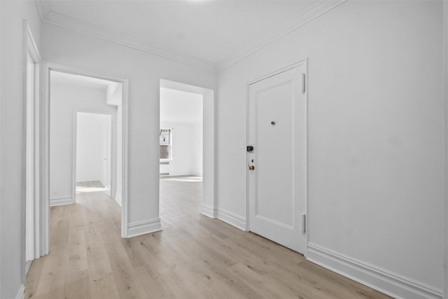 interior space with baseboards, ornamental molding, and light wood-style floors